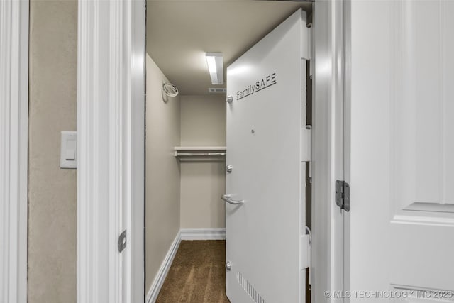 spacious closet featuring dark colored carpet