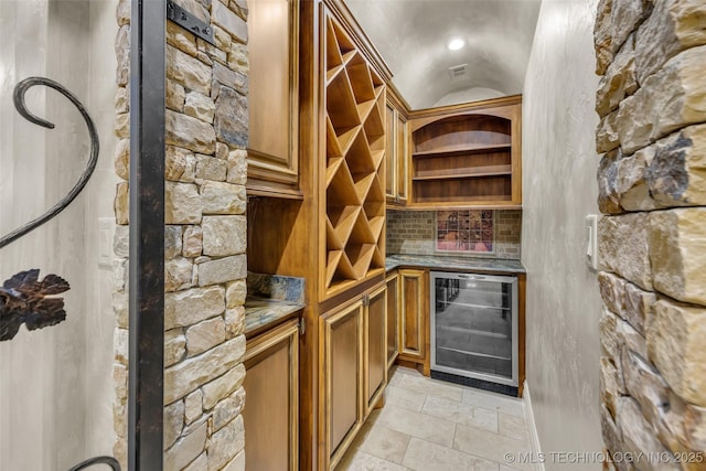 wine area featuring beverage cooler and indoor bar