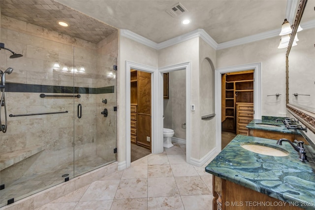 bathroom featuring an enclosed shower, vanity, crown molding, and toilet