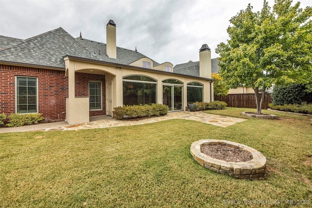 back of house featuring a lawn and a patio area