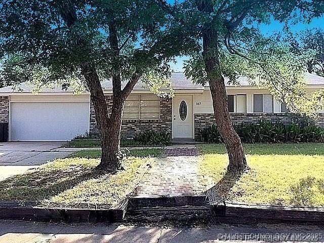 view of front of house featuring a garage and a front lawn