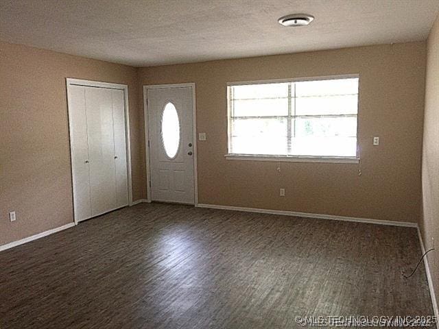 entrance foyer with dark wood-type flooring and a textured ceiling