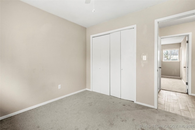 unfurnished bedroom with light colored carpet, ceiling fan, and a closet