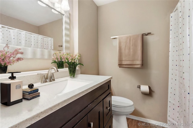 bathroom featuring vanity, hardwood / wood-style floors, walk in shower, and toilet