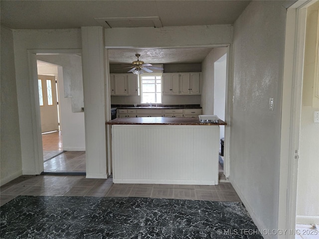 kitchen with white cabinetry, sink, and ceiling fan