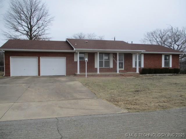 ranch-style house with a garage and a front lawn