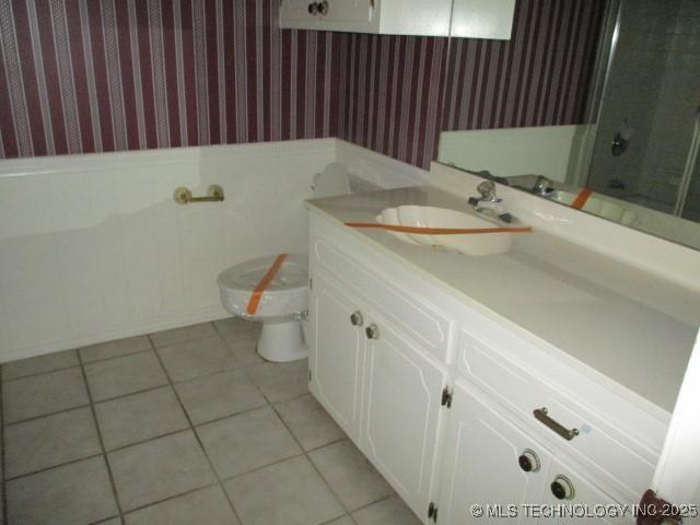 bathroom featuring vanity, toilet, tile patterned flooring, and a shower