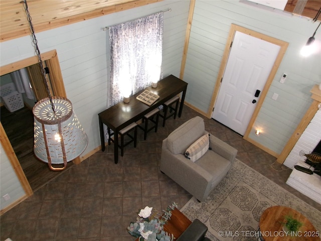 living room with wooden walls and dark tile patterned floors