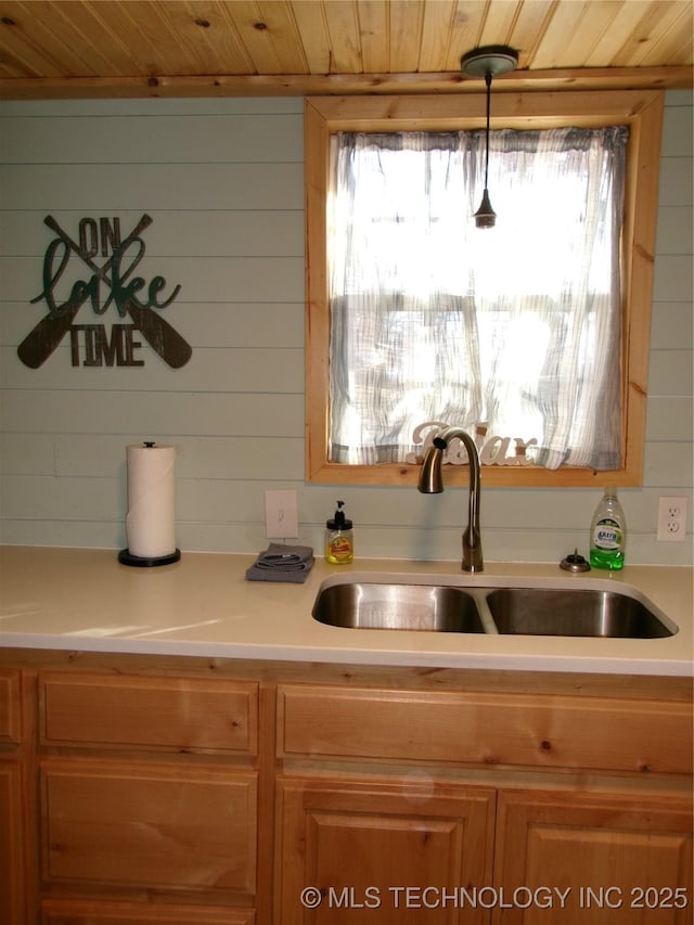 kitchen featuring hanging light fixtures, wooden ceiling, and sink