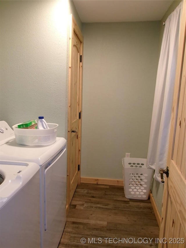 laundry area with washing machine and clothes dryer and dark hardwood / wood-style floors