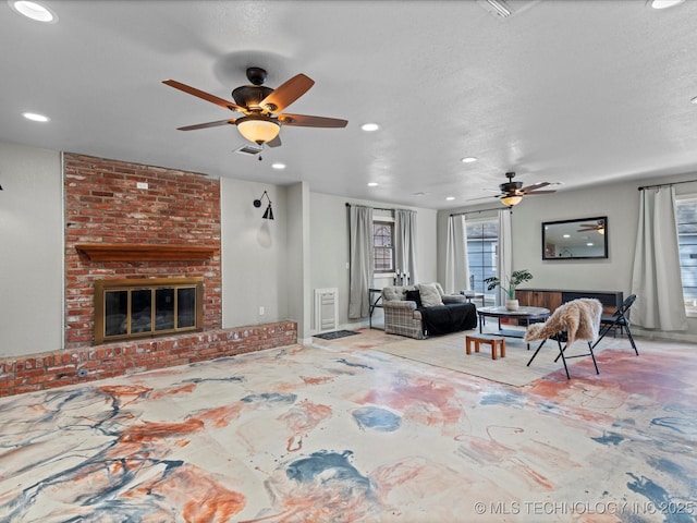 living room with a brick fireplace and a textured ceiling