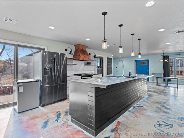 kitchen featuring an island with sink, sink, custom exhaust hood, stainless steel appliances, and plenty of natural light