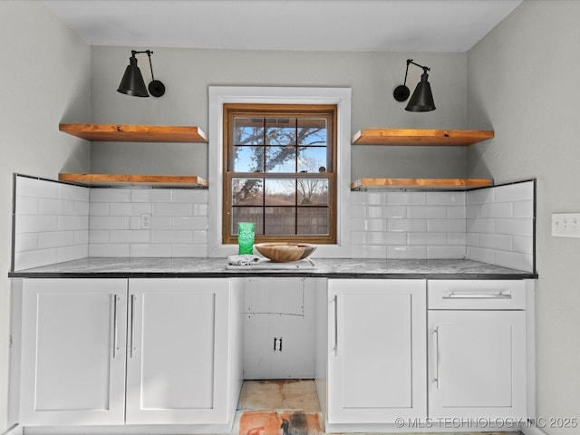 kitchen featuring tasteful backsplash and white cabinets