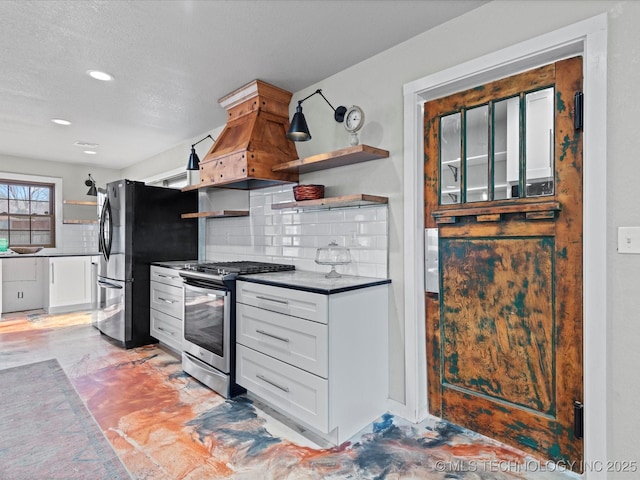 kitchen with tasteful backsplash, appliances with stainless steel finishes, custom exhaust hood, and white cabinets