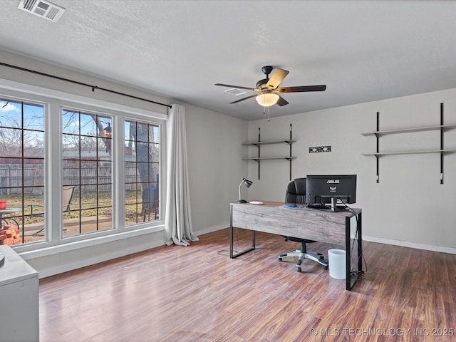 office space with ceiling fan, hardwood / wood-style floors, and a textured ceiling