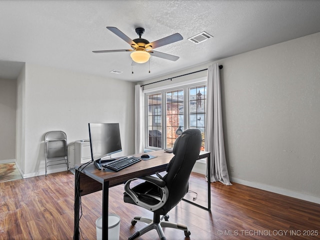 home office with ceiling fan, dark hardwood / wood-style floors, and a textured ceiling