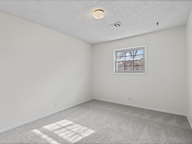 carpeted spare room featuring a textured ceiling