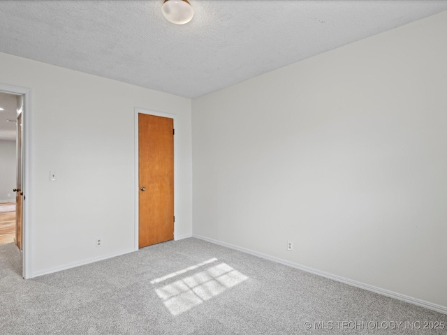 unfurnished bedroom featuring light carpet and a textured ceiling