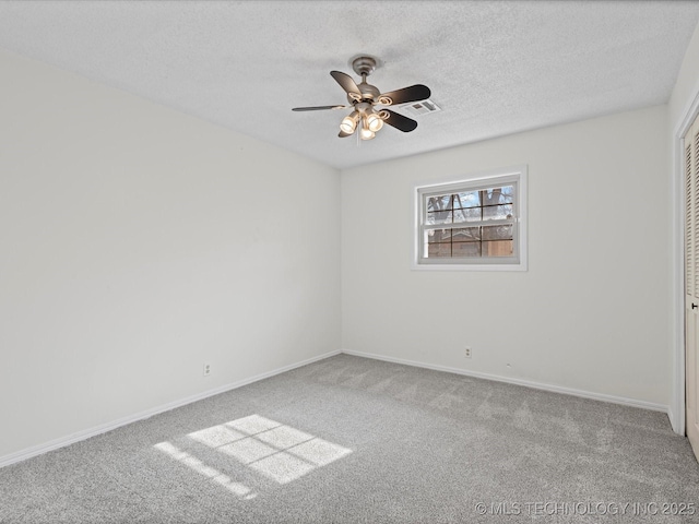 empty room with ceiling fan, carpet floors, and a textured ceiling