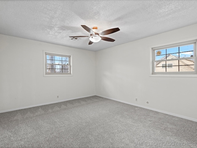 empty room with ceiling fan, carpet floors, and a textured ceiling