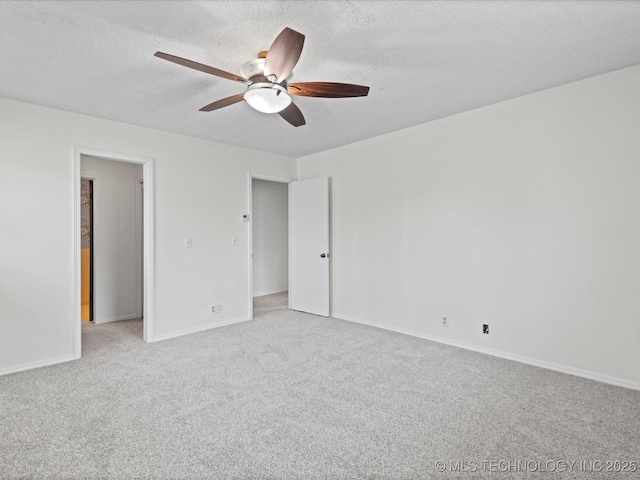 spare room with ceiling fan, light colored carpet, and a textured ceiling