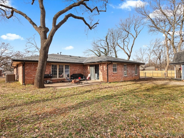 back of property with a lawn, central air condition unit, and a patio area