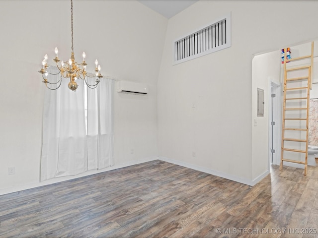 unfurnished room featuring hardwood / wood-style flooring, a wall mounted AC, electric panel, and a chandelier