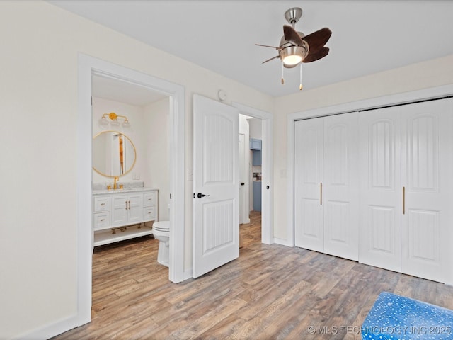 unfurnished bedroom with ensuite bath, light hardwood / wood-style floors, and a closet