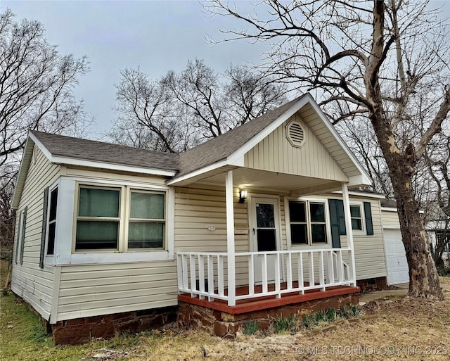 bungalow featuring covered porch and a shingled roof