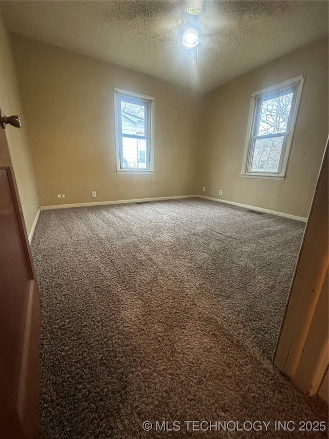 empty room with a textured ceiling and carpet