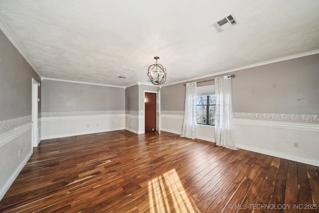 unfurnished room with crown molding, dark wood-type flooring, and a notable chandelier