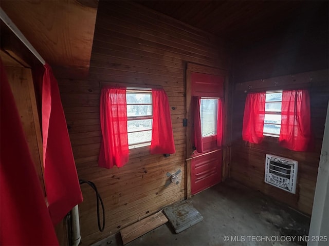 entryway featuring a wealth of natural light, heating unit, and wood walls