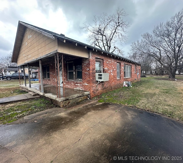 view of side of property featuring a yard and cooling unit