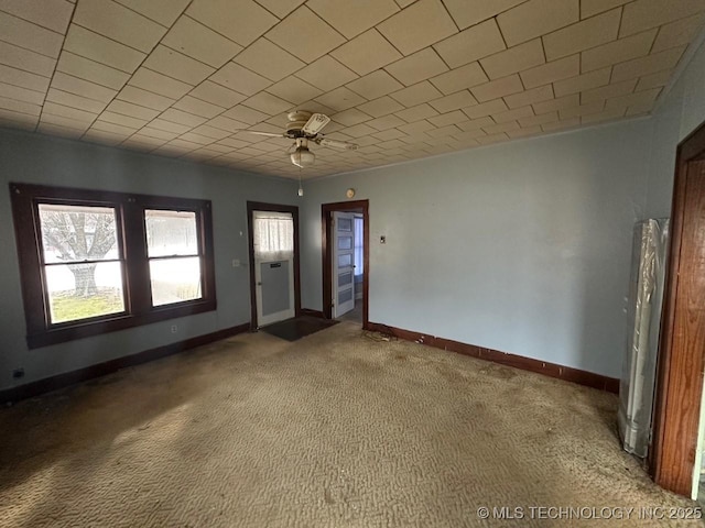 carpeted spare room with ceiling fan