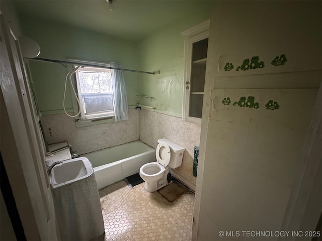 full bathroom featuring sink, washtub / shower combination, and toilet