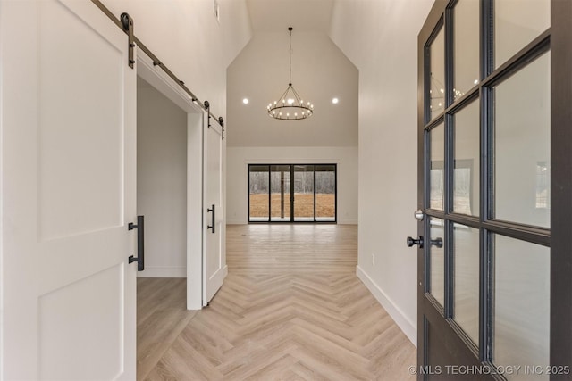 corridor featuring a barn door, a chandelier, high vaulted ceiling, and light parquet floors