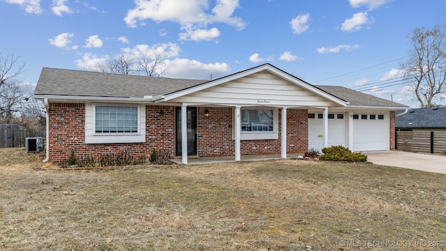 single story home with a garage, a front yard, and central air condition unit