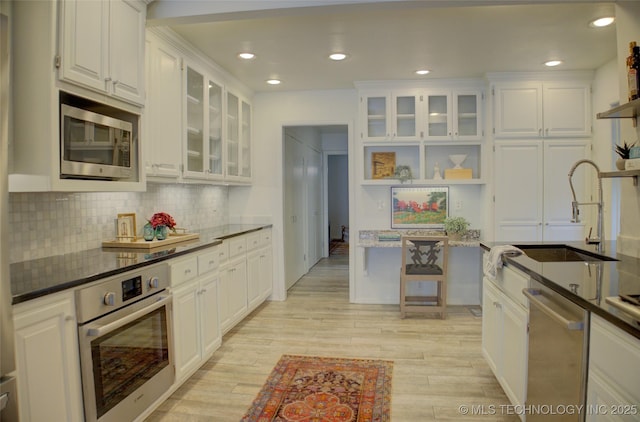 2411 E 72nd Pl Unit 2-A-3, Tulsa, OK 74136 - kitchen featuring appliances with stainless steel finishes, white cabinets, backsplash, and recessed lighting