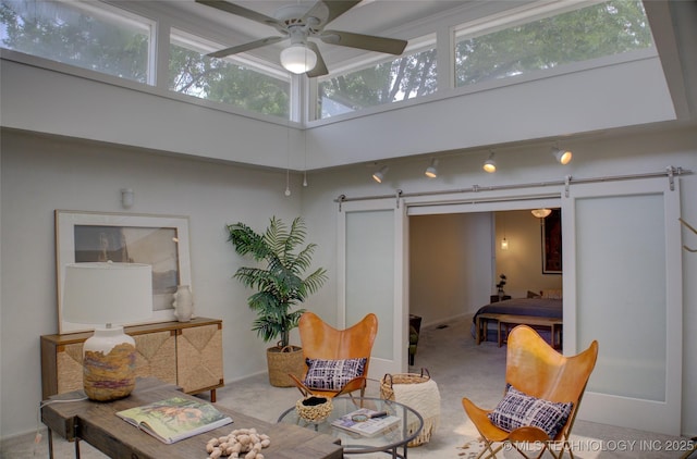 2411 E 72nd Pl Unit 2-A-3, Tulsa, OK 74136 - carpeted living room with a barn door, a ceiling fan, and a towering ceiling