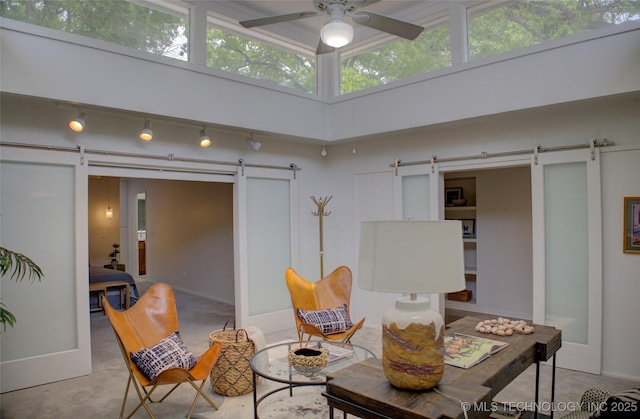 2411 E 72nd Pl Unit 2-A-3, Tulsa, OK 74136 - living area featuring a barn door, a ceiling fan, carpet, and rail lighting