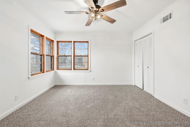 unfurnished bedroom featuring carpet, ceiling fan, and a closet