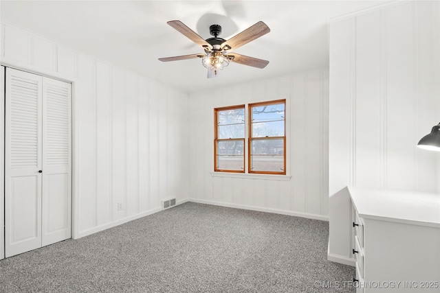 unfurnished bedroom with ceiling fan, a closet, and carpet