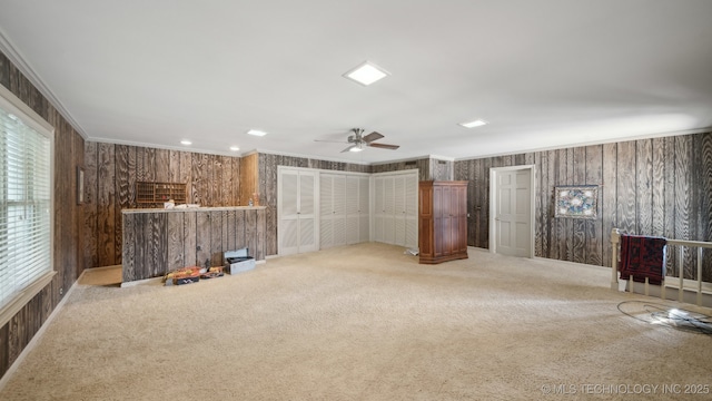 interior space with crown molding, carpet floors, and ceiling fan