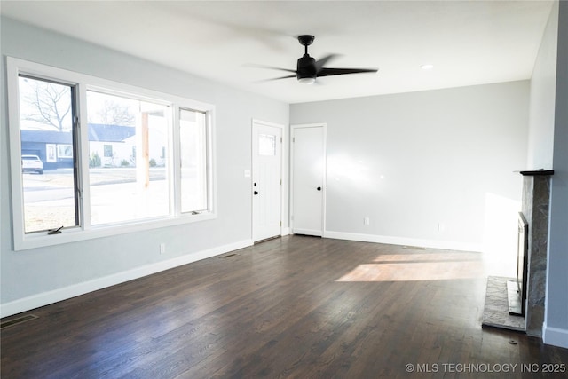 unfurnished living room featuring dark hardwood / wood-style floors and ceiling fan