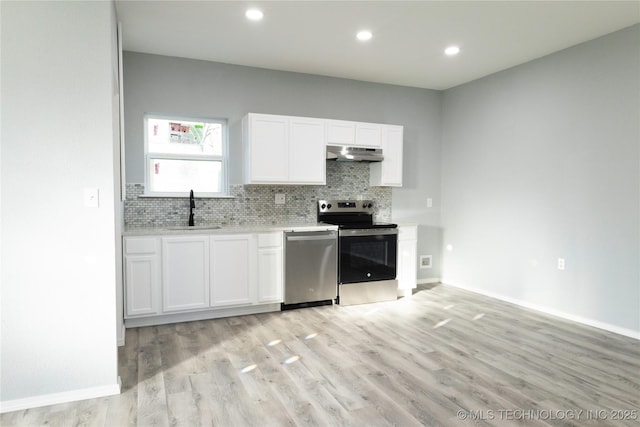 kitchen featuring under cabinet range hood, tasteful backsplash, stainless steel appliances, and a sink