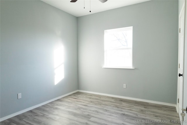 unfurnished room with a wealth of natural light, baseboards, and wood finished floors