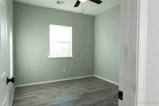 empty room with ceiling fan, wood finished floors, visible vents, and baseboards