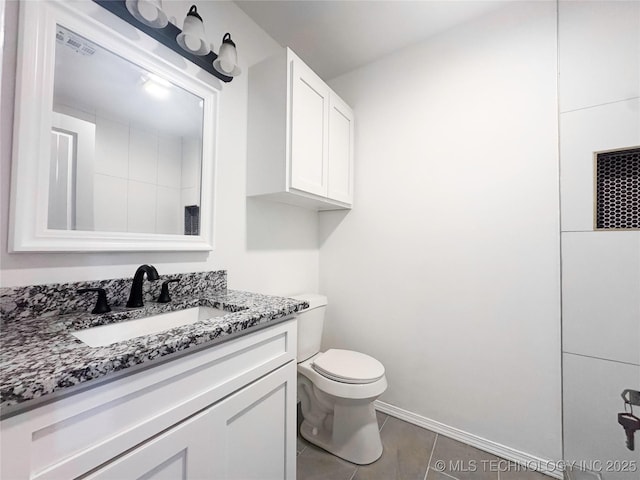 bathroom featuring toilet, baseboards, vanity, and tile patterned floors