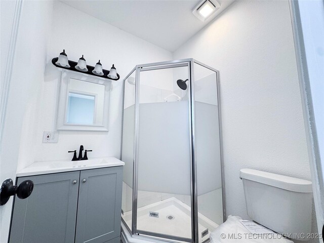 full bath with a stall shower, vanity, and toilet