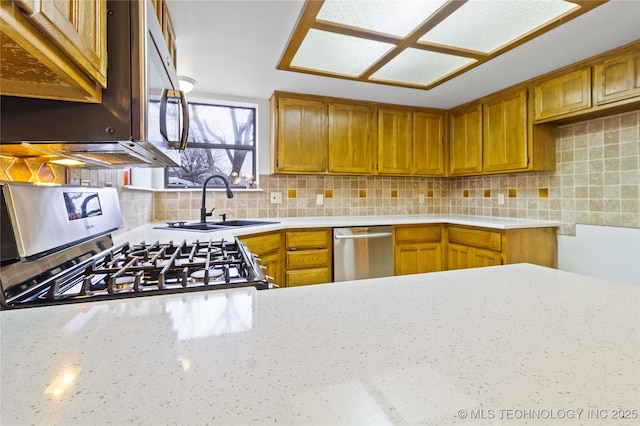 kitchen with appliances with stainless steel finishes, sink, and backsplash